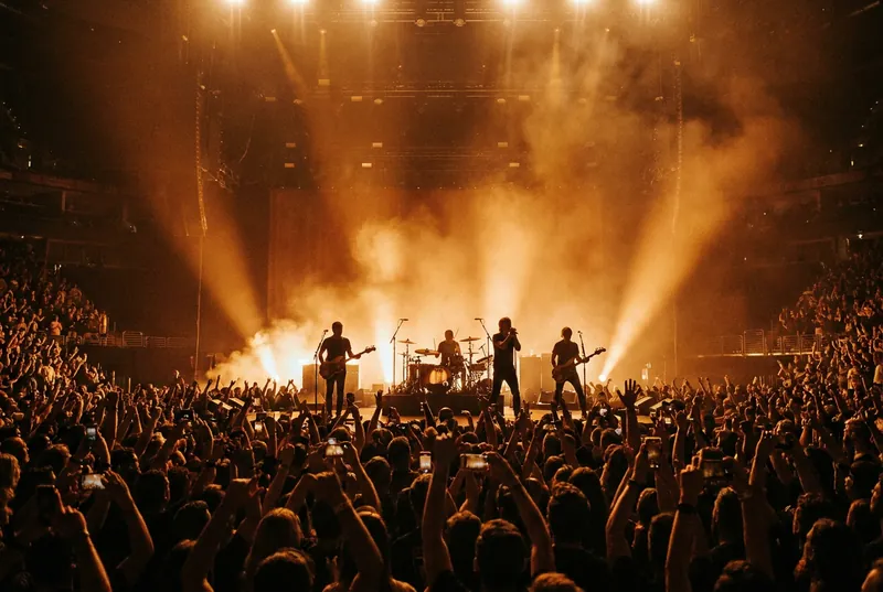A band performing on stage with dramatic lighting to a cheering crowd, illustrative image for The Click Five's Hong Kong show