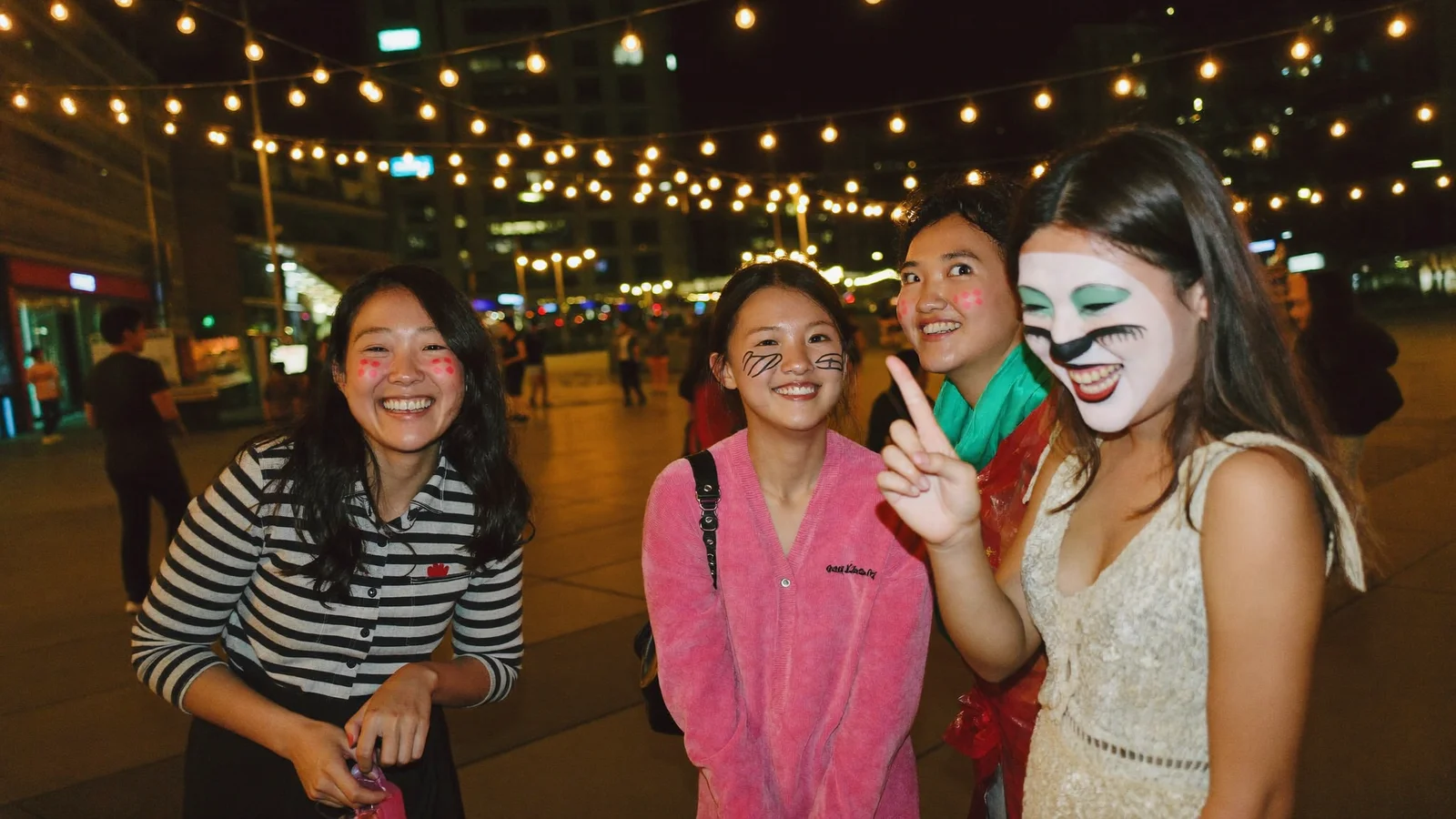 Illustrative image of friends in Halloween face paint on a Hong Kong street at night