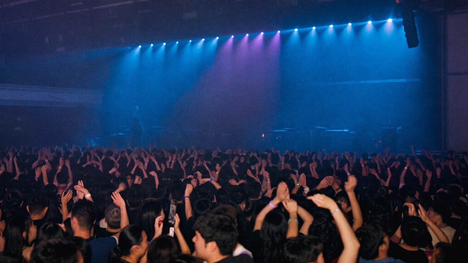 Illustrative image of an arena crowd facing a brightly lit concert stage